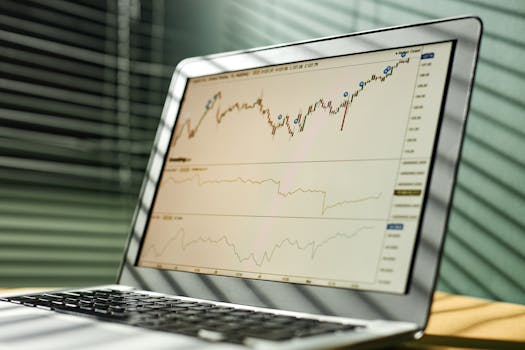 Close-up of a laptop displaying stock market data and graphs in an office setting.